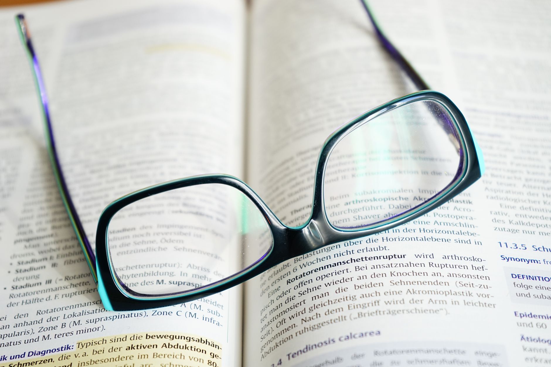 Academic Research, Research Assistant, For Literature Review, Paper Writing Hel — Reading glasses resting on an open textbook, symbolizing 