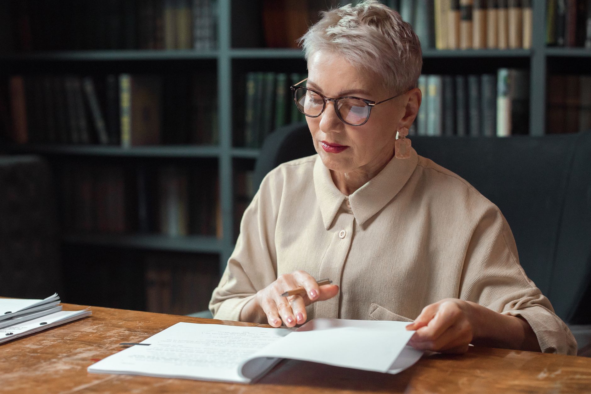 Academic Research, Research Assistant, For Literature Review, Paper Writing Hel — Elderly woman with glasses reading documents at a desk in
