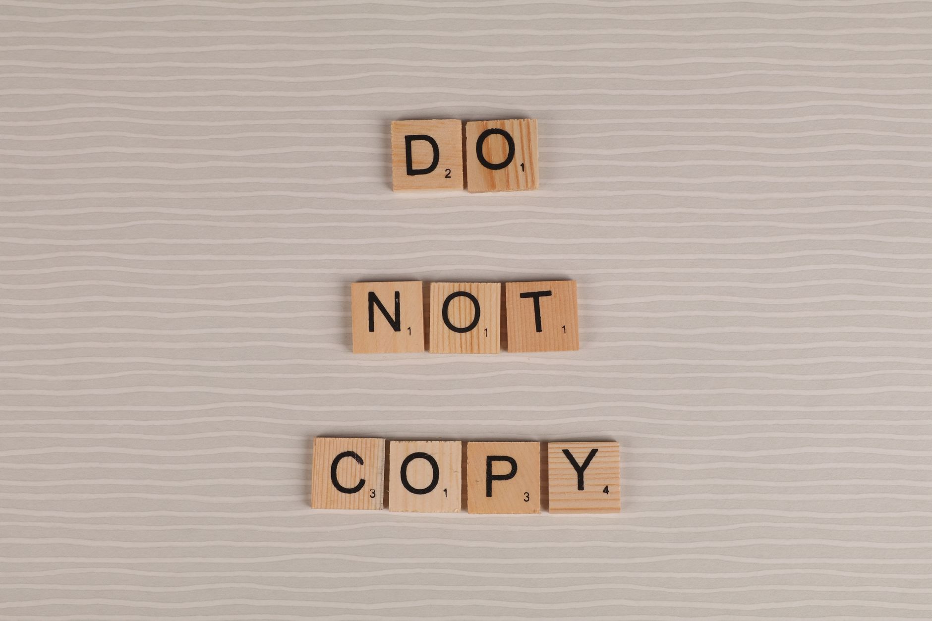 Ad Copy, Ad Copy Writer, Generate Ad Copy With, High Converting Ad Copy, Adv — Close-up of wooden tiles spelling Do Not Copy on a textur