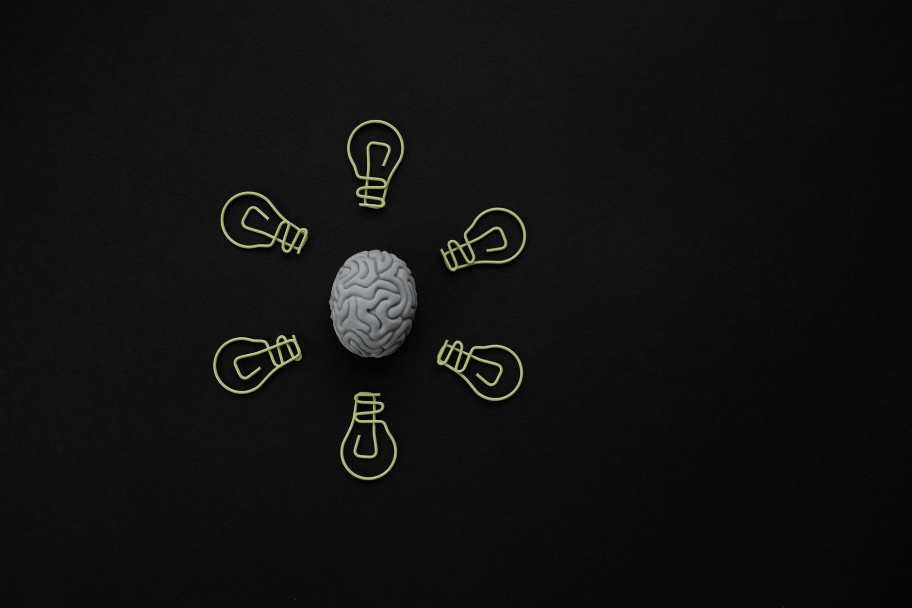 Animation Idea — Conceptual photo of a brain surrounded by light bulb clips on black background.