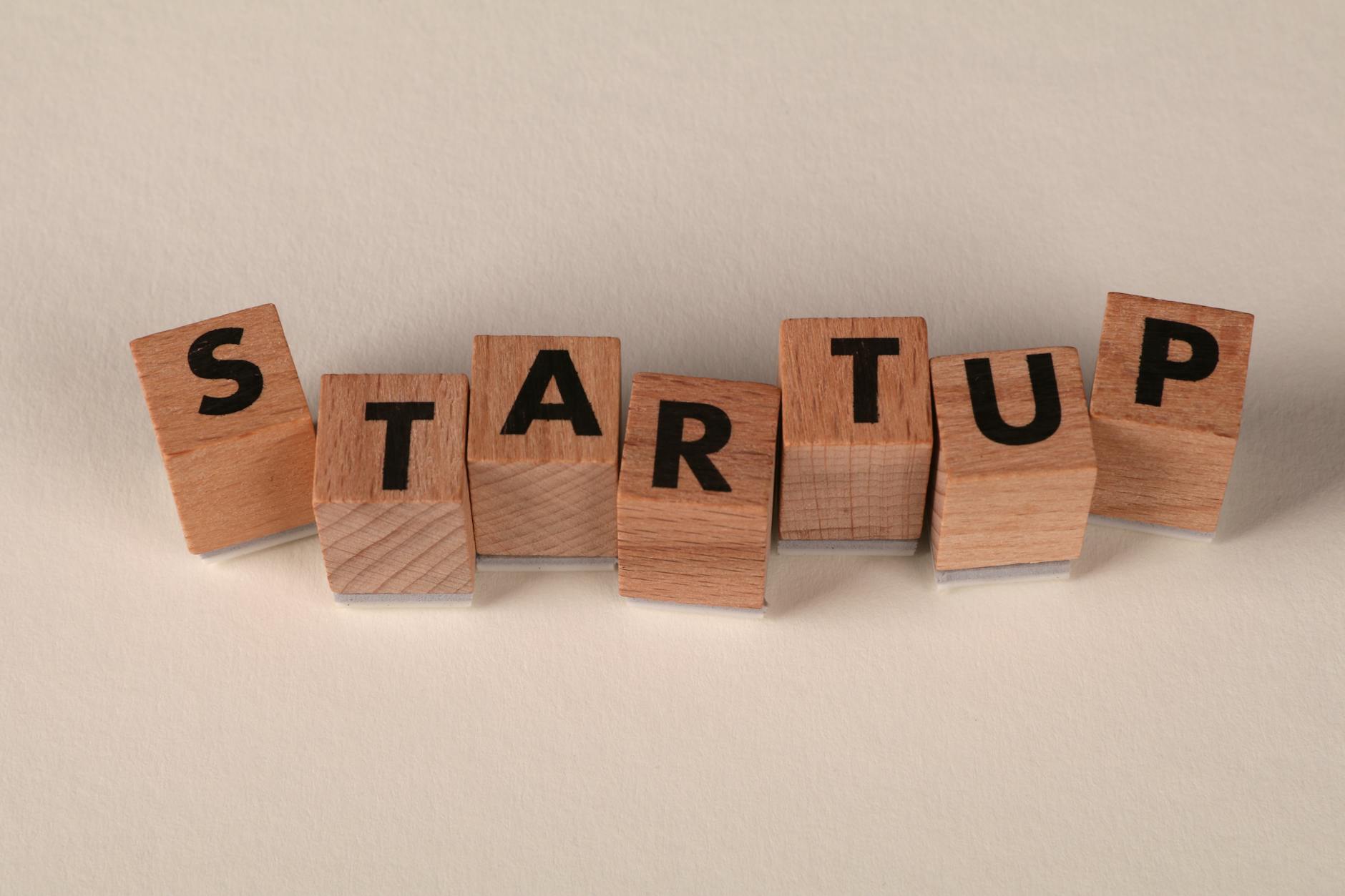 Business Name, Company Name, Brand Name, Startup Name Ideas — Wooden blocks forming the word STARTUP on a neutral background, symbolizing