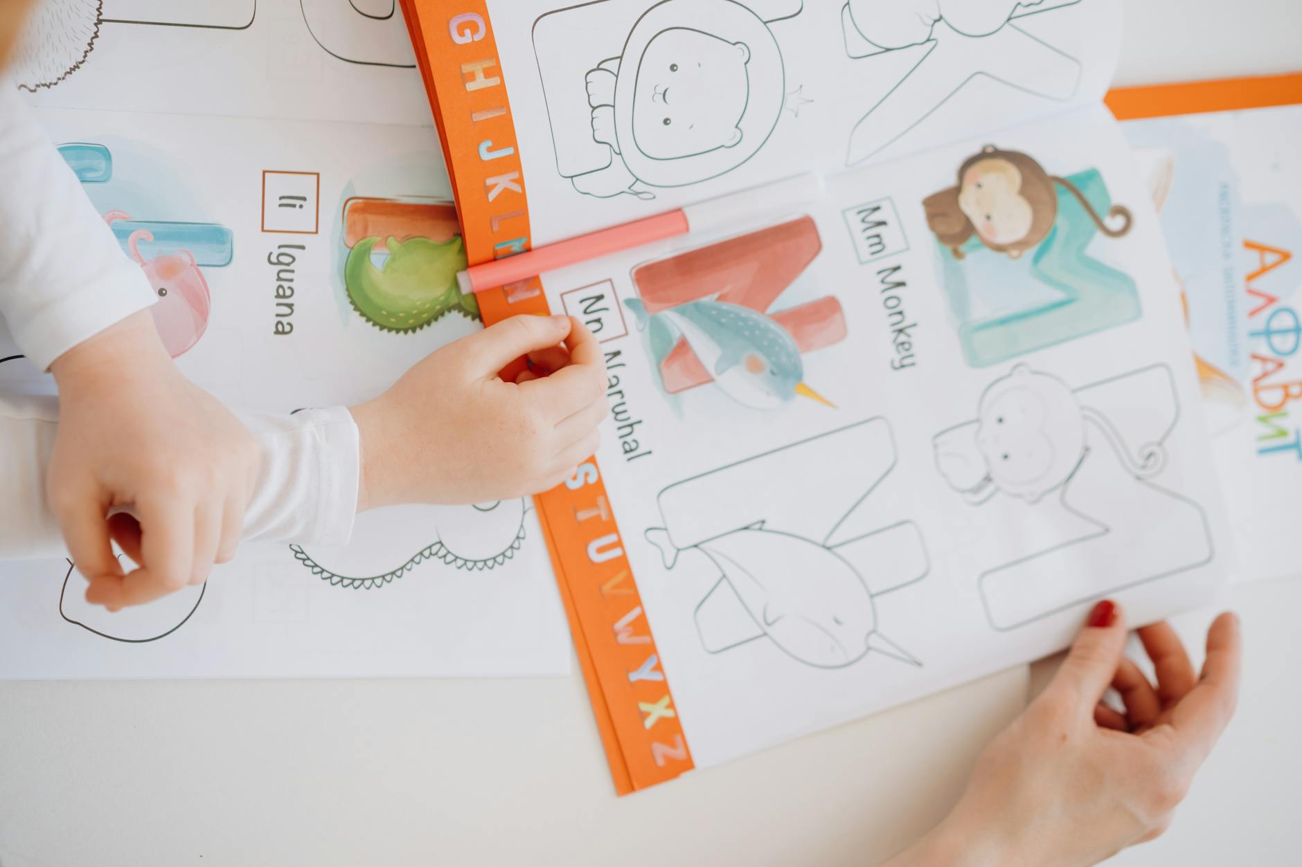 Coloring Page — Children engage in learning the alphabet using a coloring book with bright illustrations.