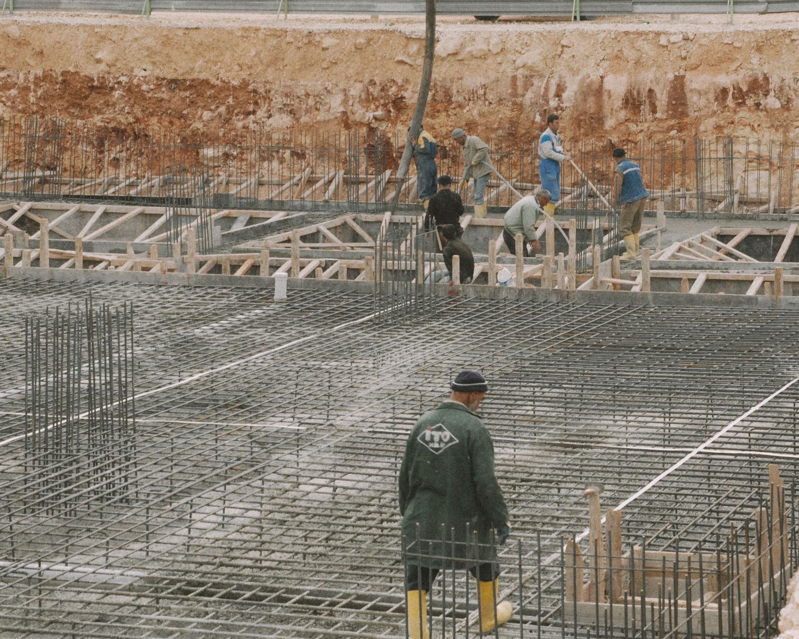 For Construction, Construction Assistant, For Building, For Contractors — Workers building a foundation with rebar at a construction site.