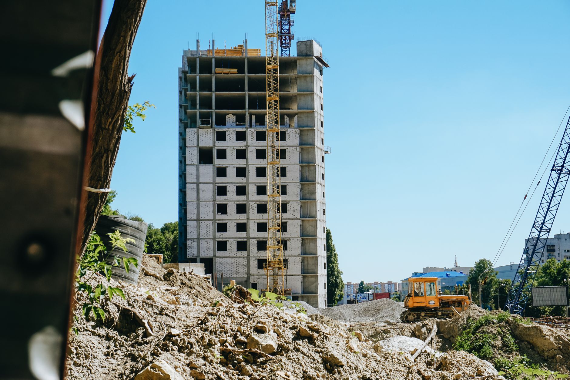 For Construction, Construction Assistant, For Building, For Contractors — Mid-rise building under construction with cranes and machinery in