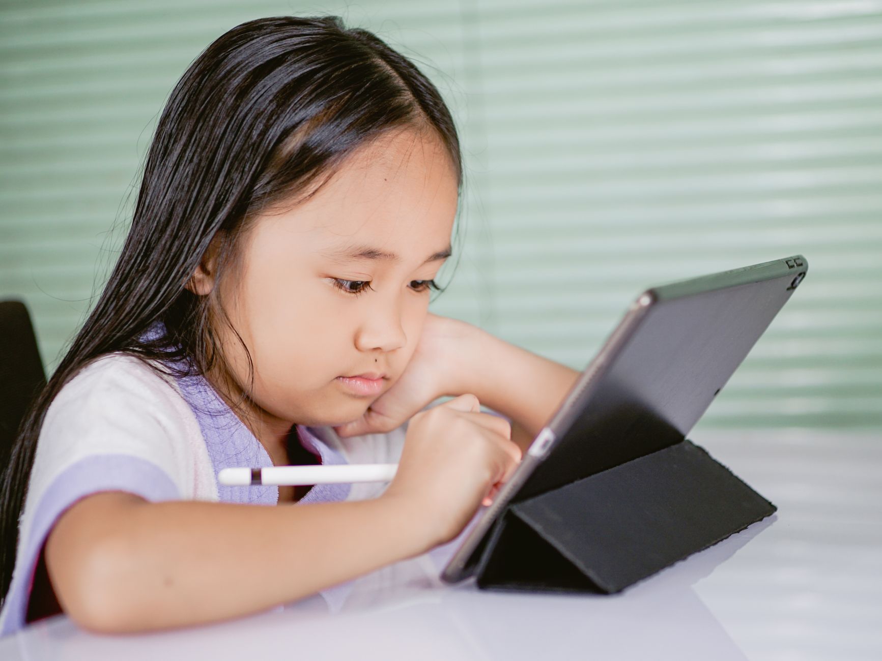 For Education, -Powered Learning Tools, Study Assistant, Learn Smarter With, Tu — A young girl using a tablet for online learning, focused 