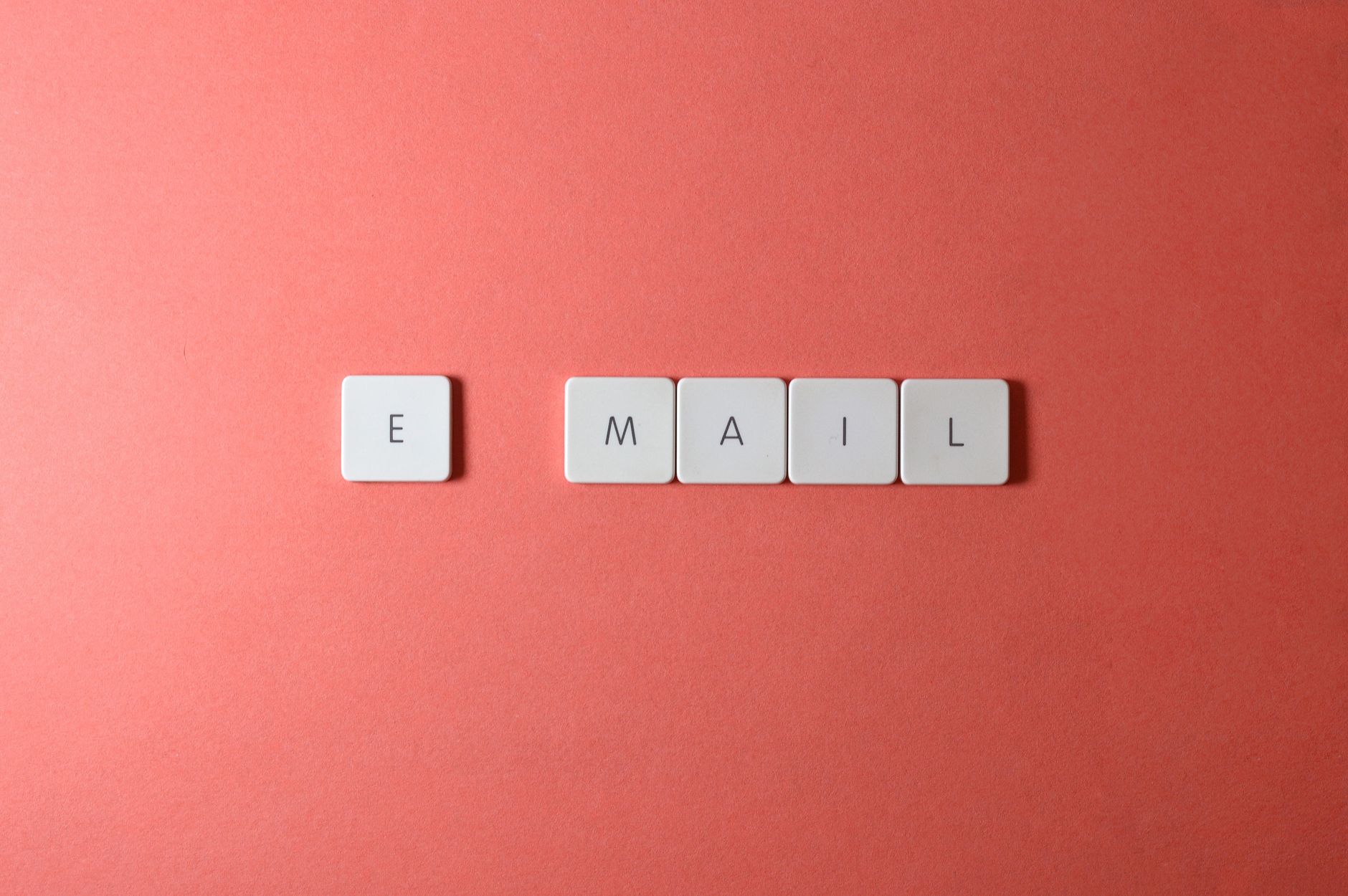 For Email, Email Writer, Email, For Email Management, For Email Writing — Flat lay of keyboard letter tiles spelling email on coral backdro