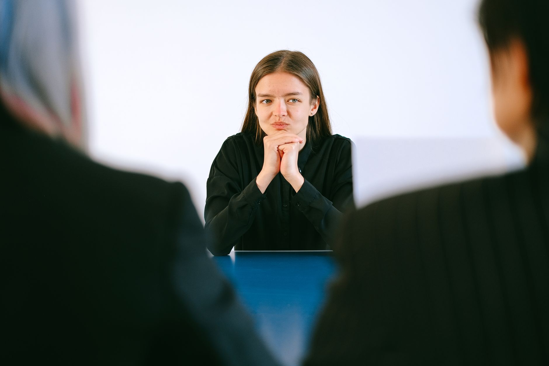 For Hr, For Human Resources, For Recruiting, For Hiring — A woman in a job interview facing two people at an office table, focusing intently
