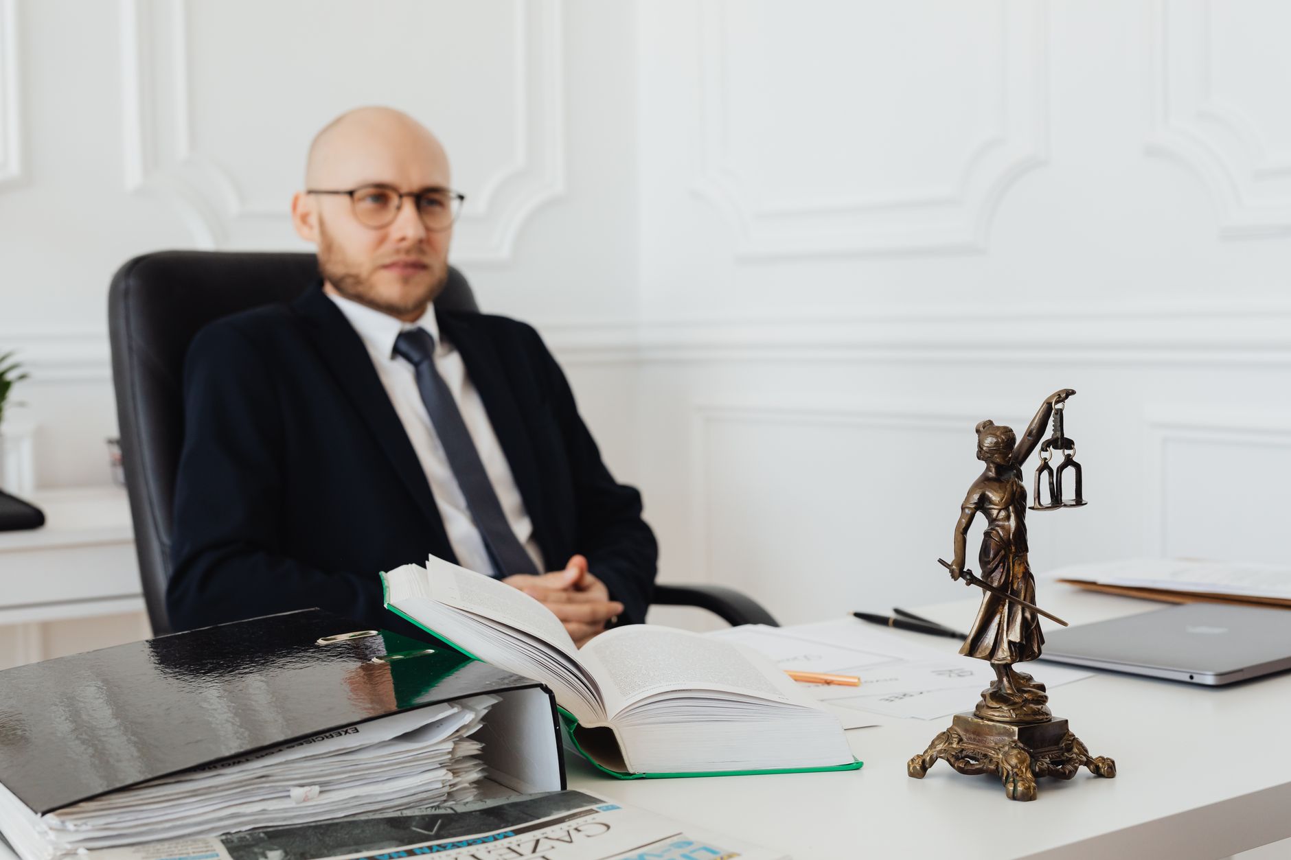 For Lawyers, Legal Assistant, For Law Firms — Bald lawyer in office sitting with legal documents and Justice statue.