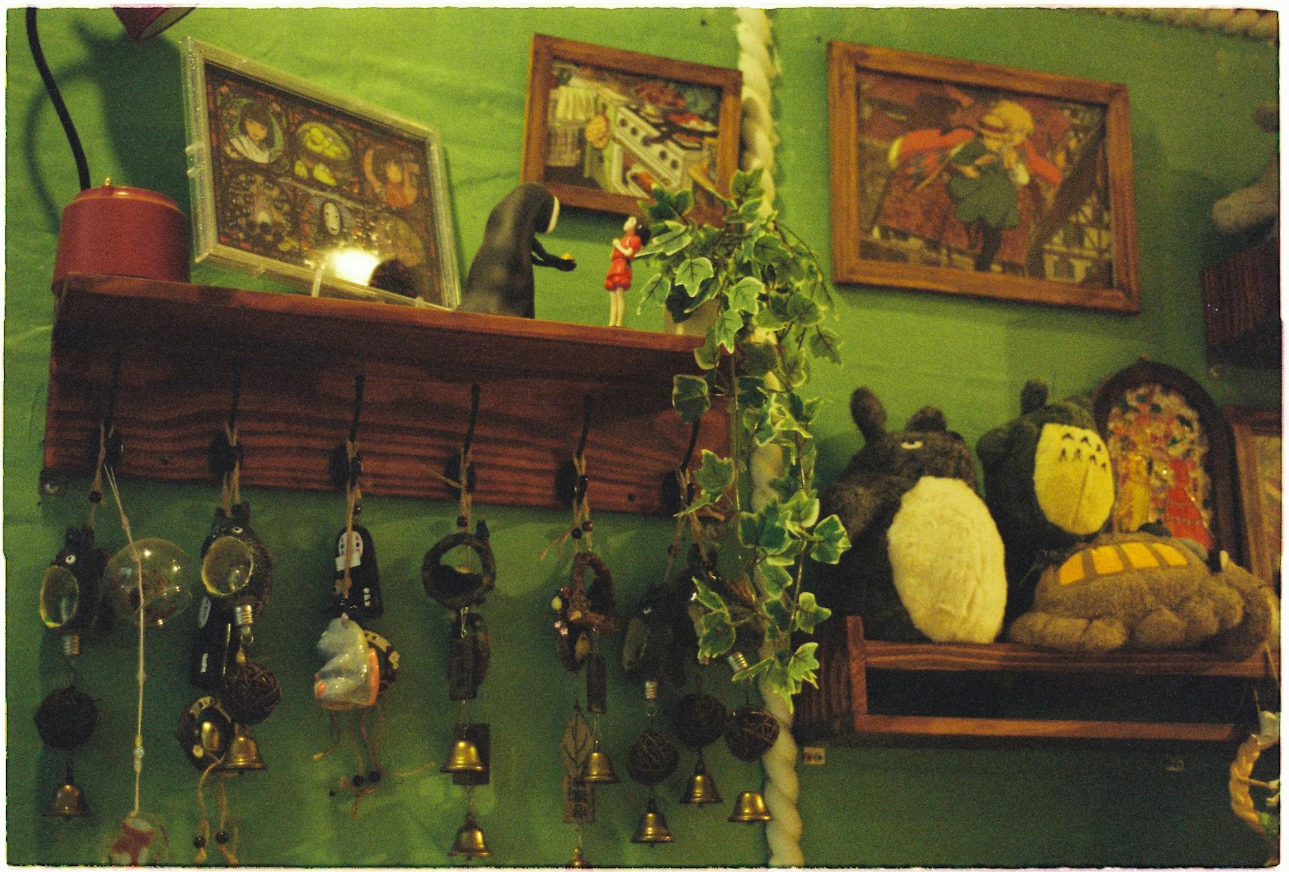 Ghibli Art — A charming indoor scene featuring decorated shelves with art and plush toys in a cozy room.