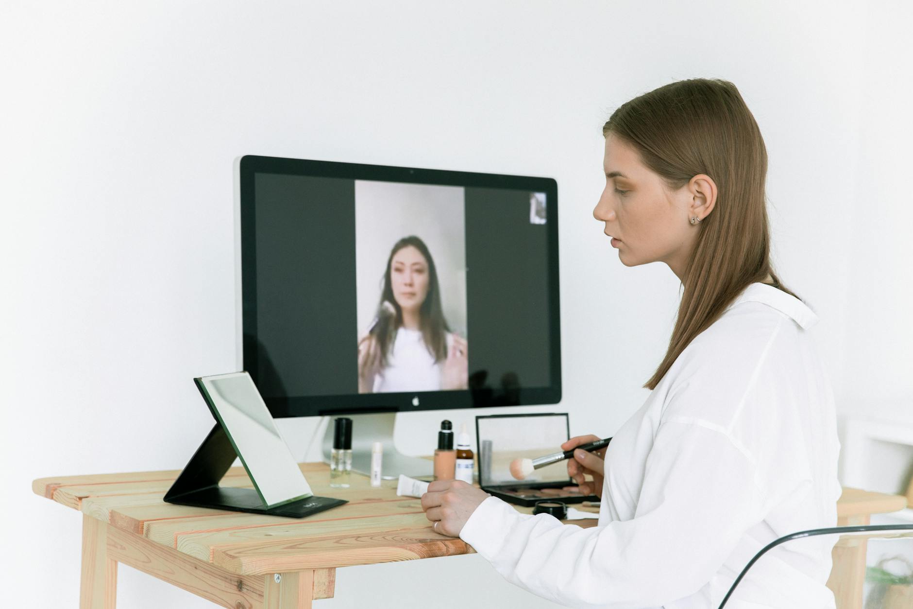 Makeup, Virtual Makeup Try On, Beauty Filter, Virtual Makeover Online, Cosmetic — A woman applies makeup while following an online beauty t