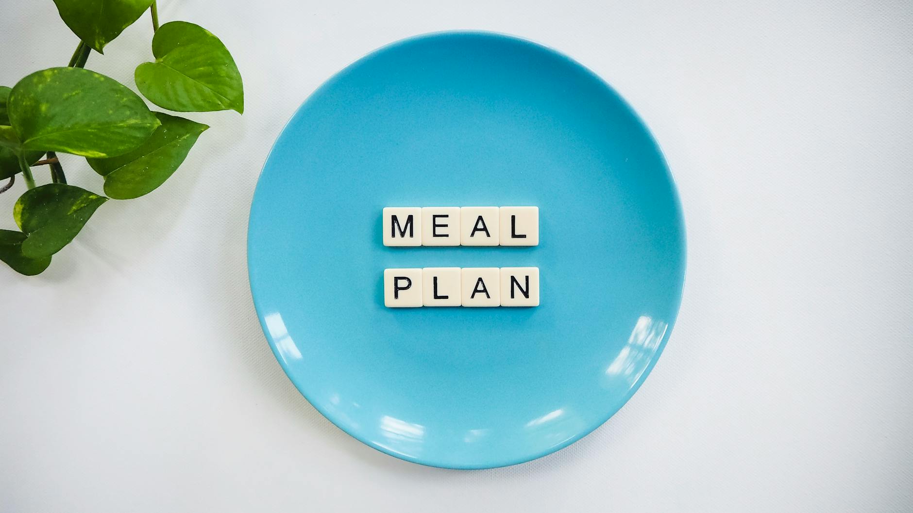 Meal Planner, Meal Plan, Diet Plan — Innovative meal planning concept using alphabet tiles on a blue plate with green leaves.