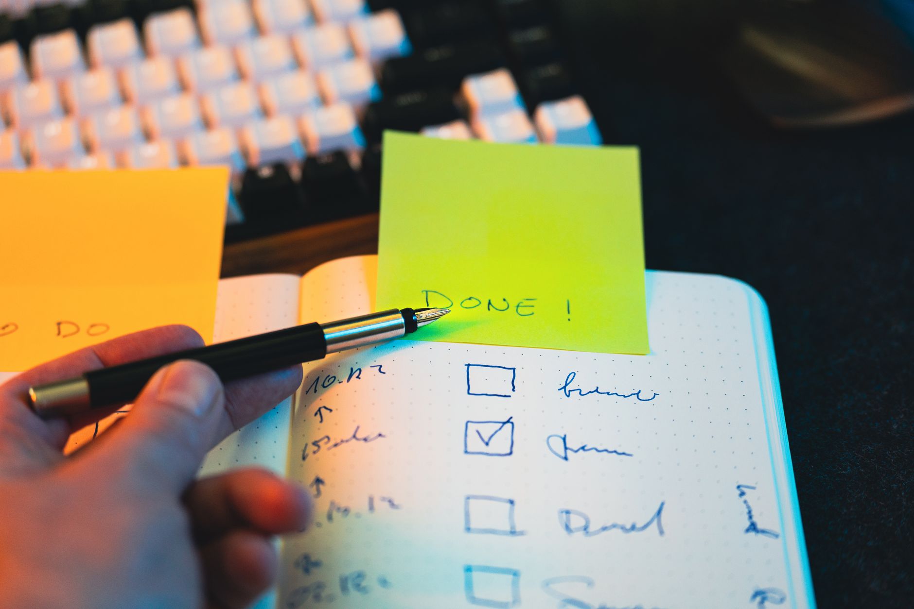 Productivity Tools, Task Management, Workflow Automation, Get More Done With, P — Close-up of hand holding pen over notebook checklist with