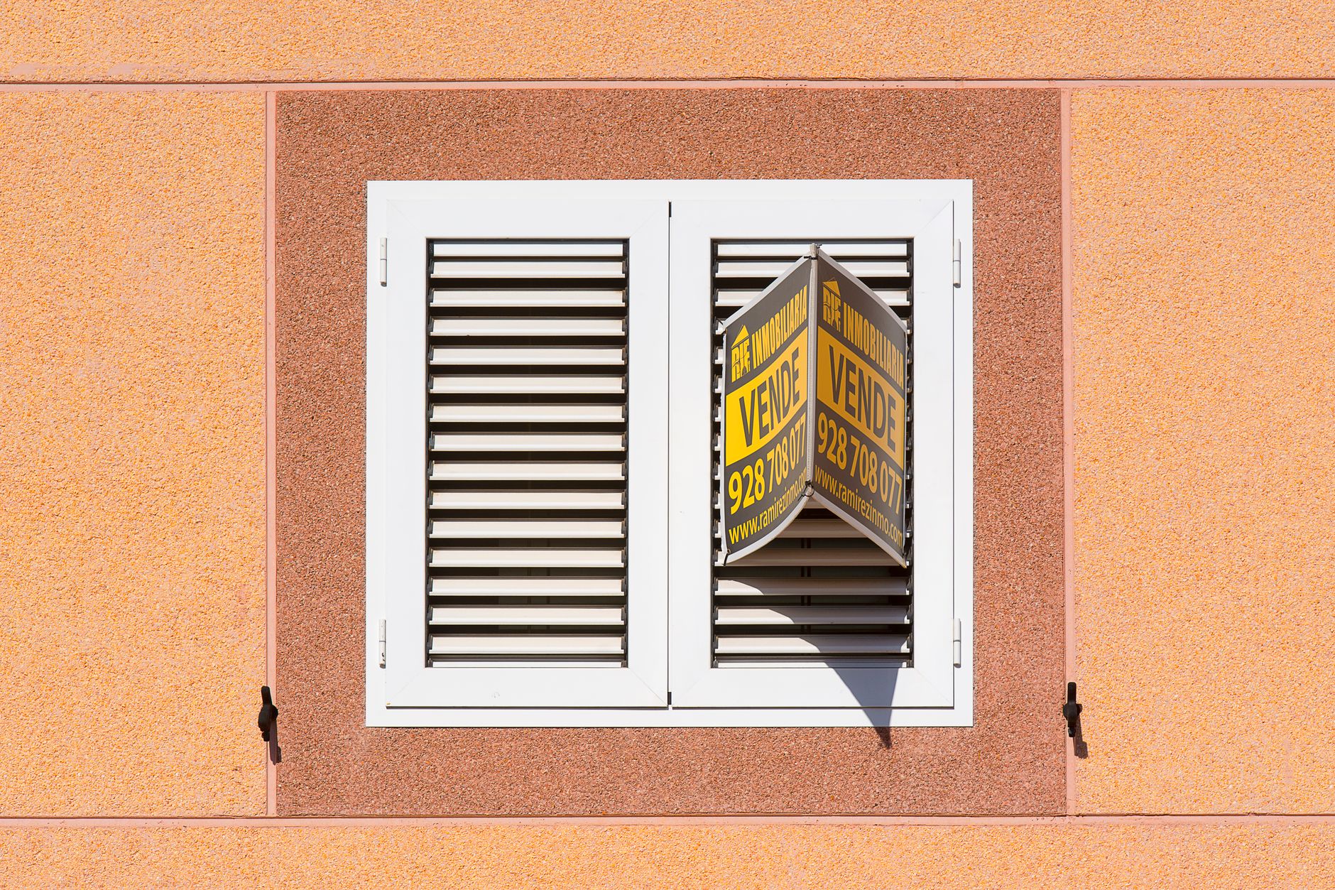 Real Estate Tools, Property Description, Real Estate Market Analysis, Listing — White shutter window with a for sale sign on peach buildi
