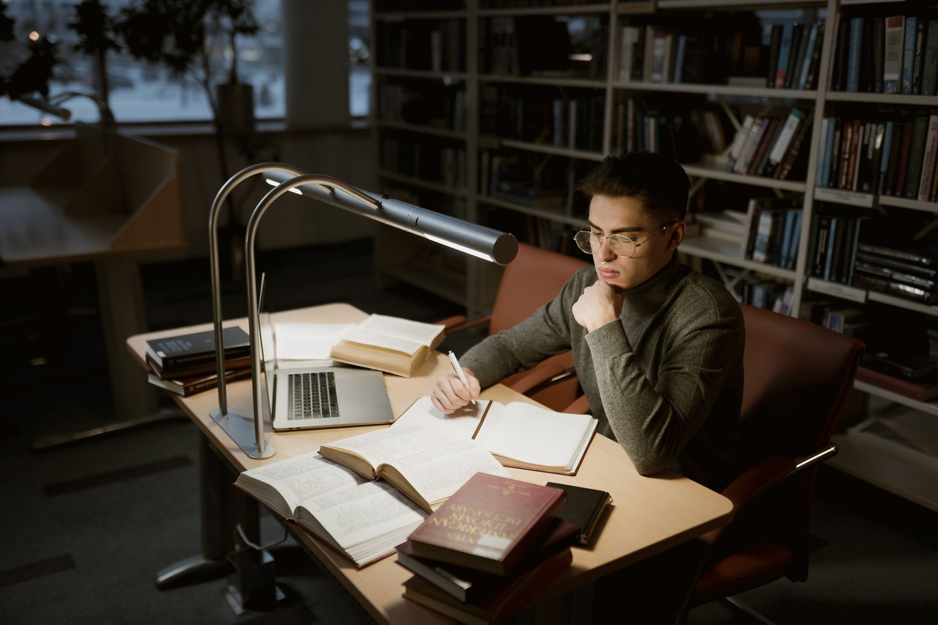 Research Assistant, For Academic Research, Powered Research, Literature Review, — A young adult studying at a library desk with books and l