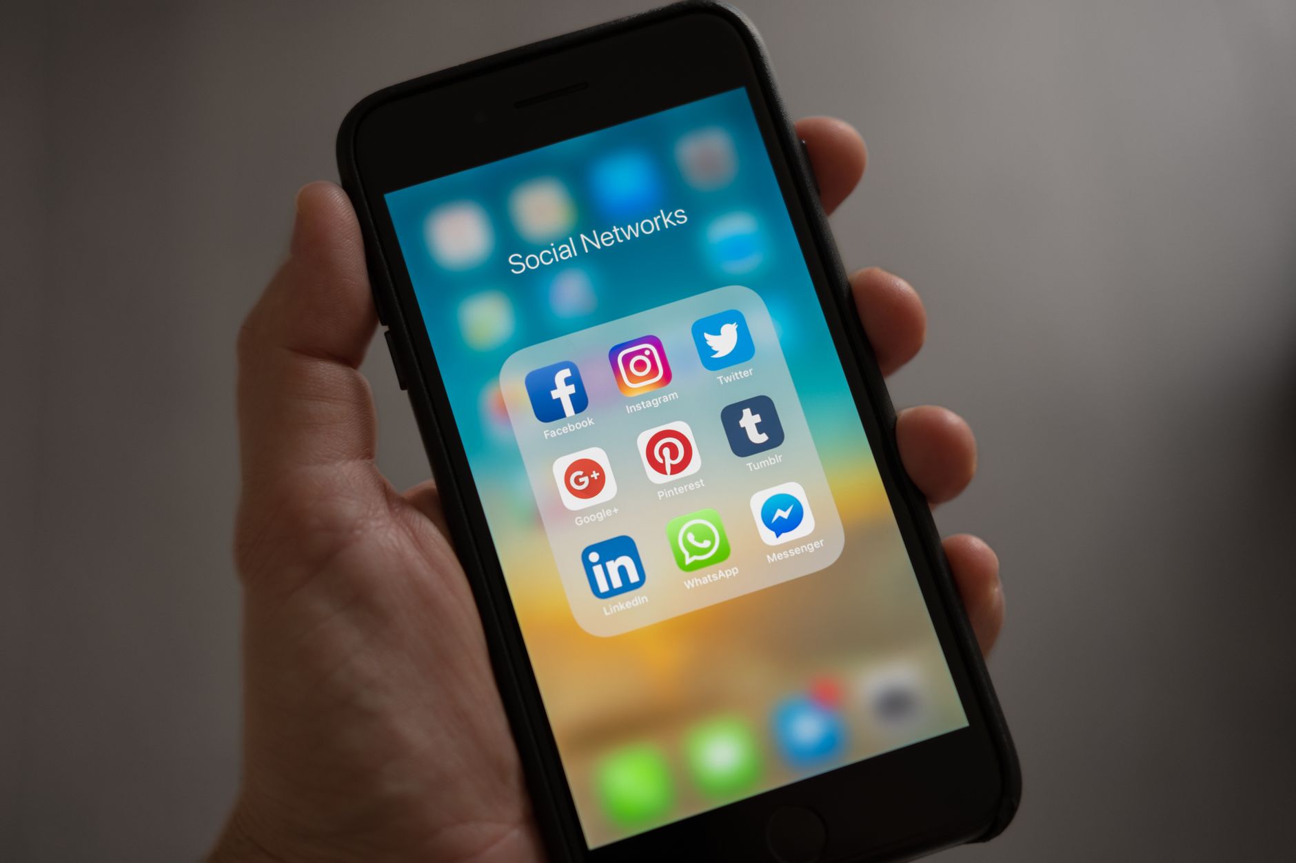 Social Media Post, For Social Media, Instagram Caption, Twitter Post, Linkedin — A smartphone displaying various social media icons held i