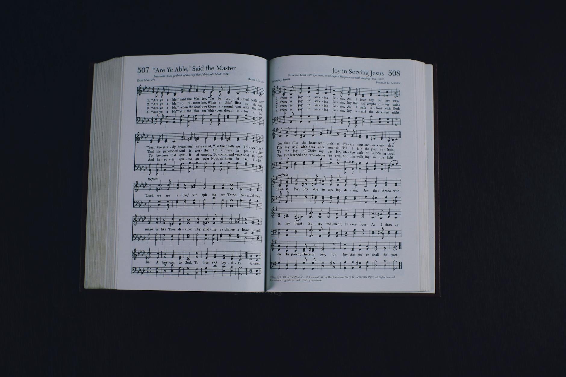 Song Lyrics, Lyric Writer, Song, Rap Lyrics — From above of pages of opened book with music notes placed on black background