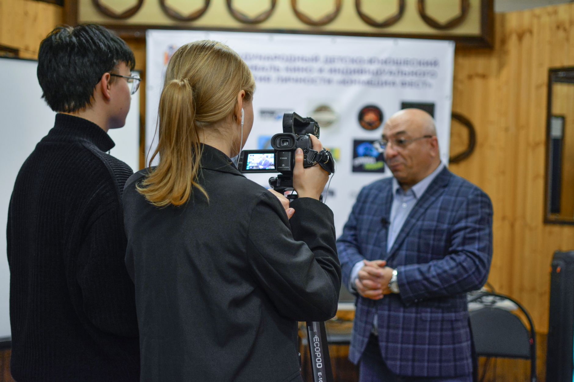 Subtitle, Auto Captions, Video To Srt, Captions, Subtitle — A journalist records an interview with a man using a camcorder indoors.