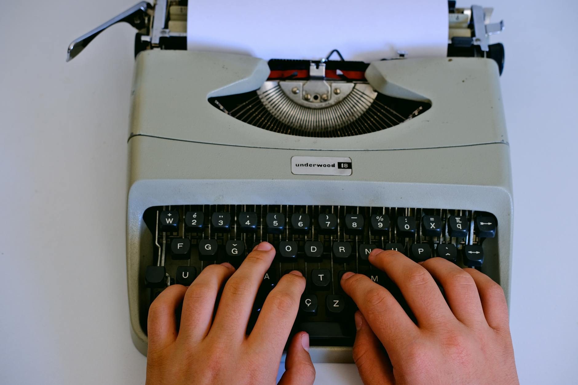 Writing Assistant, Content, Write Faster With, Writing, Smart Writing, Parag — Close-up of hands typing on a classic Underwood typewrite