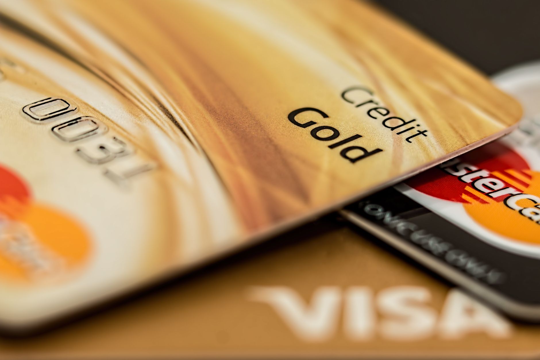 Best For Finance — Stack of various branded credit cards focusing on gold card showing finance and cashless concept.