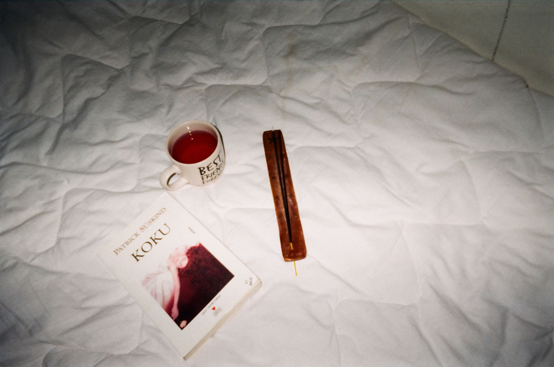 Best For Interior Design — A warm still life featuring a book, mug of tea, and incense on a bed.