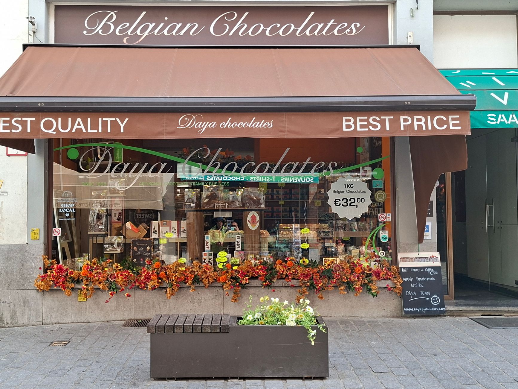 Best For Marketing — Colorful street view of a delightful Belgian chocolate shop with floral decorations in Bruges.