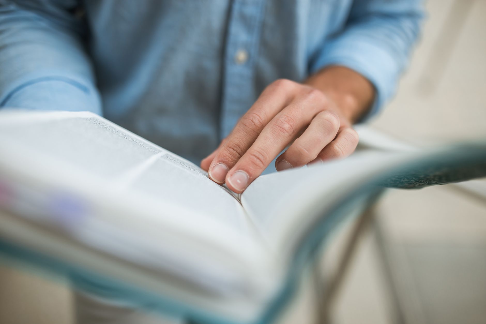 Study Guide — A focused shot of a hand flipping through pages of a book, showing intricate hand details.